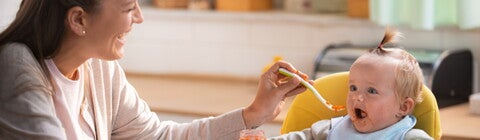 Mom feeding her baby with a spoon